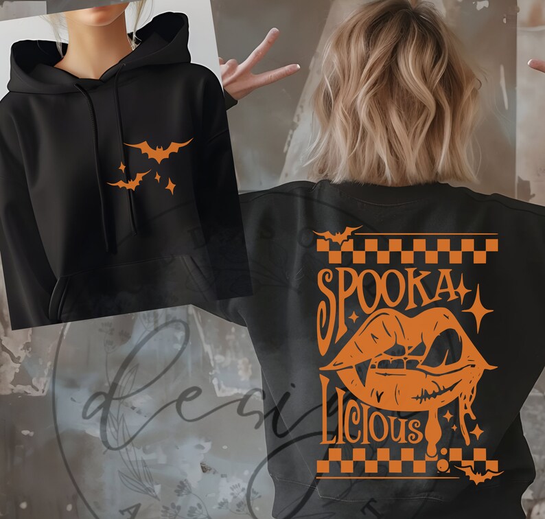 May include: Black hoodie with orange bat and star graphics on the front. The back of the hoodie features the words "Spooka Licious" with a vampire mouth graphic, all in orange. A Halloween-themed sweatshirt.