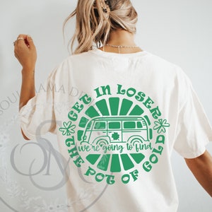 May include: Cream-colored t-shirt with a green graphic on the back. The graphic features a retro van, shamrocks, and the text "GET IN LOSER, we're going to find the pot of gold."