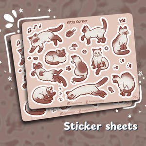 May include: Two sticker sheets featuring various cat illustrations in brown and white. The stickers have a light pink background with the text "Kitty Korner" at the top. The words "Sticker sheets" are at the bottom.