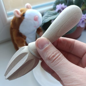 May include: A wooden citrus juicer with a textured surface and a handle. The juicer is designed to squeeze lemons, limes, and oranges.