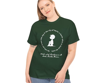 May include: A dark green t-shirt featuring a white circular design with text and a silhouette of Charlie Brown. The text reads "That's what Christmas is all about, Charlie Brown."