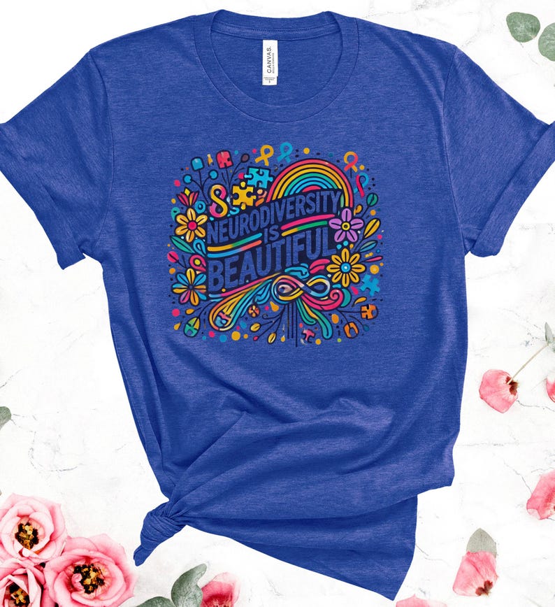 May include: A royal blue t-shirt with a colorful graphic design featuring flowers, a rainbow, and the text "Neurodiversity is Beautiful".