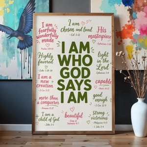 Puede incluir: Una lámina decorativa rectangular en un marco de madera con el texto I AM WHO GOD SAYS I AM en letras verdes grandes. Alrededor del texto central hay frases más pequeñas en letra cursiva rosa y verde, incluyendo I am fearfully wonderfully made.