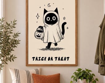 May include: A framed wall art print featuring a black cat wearing a white ghost costume and holding a jack-o'-lantern bucket. The illustration includes stars and a crescent moon, with the text TRICK OR TREAT printed in black at the bottom.