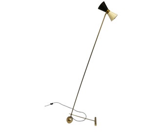 May include: A mid-century modern floor lamp with a black and white conical shade. The lamp has a brass-colored stem and base, and a black electrical cord. The lamp is angled and stands on a round base.