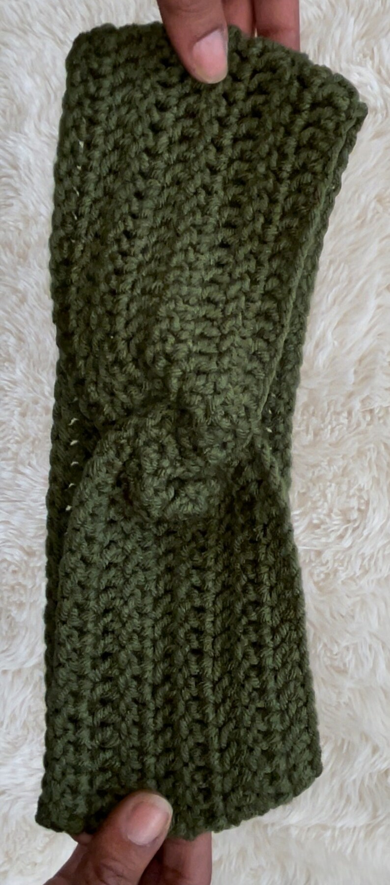 May include: A green crocheted headband with a twisted knot design.