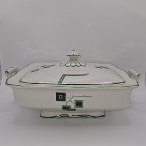 May include: White ceramic serving dish with a lid. The dish has a green and black geometric design. The lid has a scalloped edge and a knob on top.