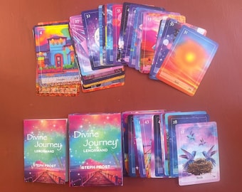 May include: A set of 36 colorful tarot cards with a starry background. The cards are arranged in two rows. The top row has the cards face up, and the bottom row has the cards face down. The cards are labeled with numbers and have images of various symbols. The box for the cards is also visible in the image. The box is blue and has the words "Divine Journey Lenormand" printed on it.