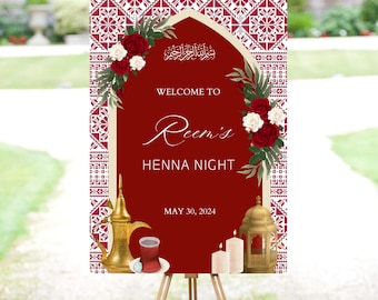 May include: A red and gold welcome sign for a henna night. The sign features an ornate archway with floral decorations, a traditional Arabic inscription, and the text "Welcome to Reem's Henna Night, May 30, 2024".