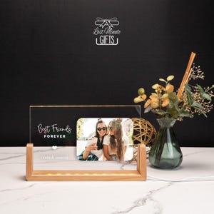 a picture frame sitting on top of a table next to a vase of flowers