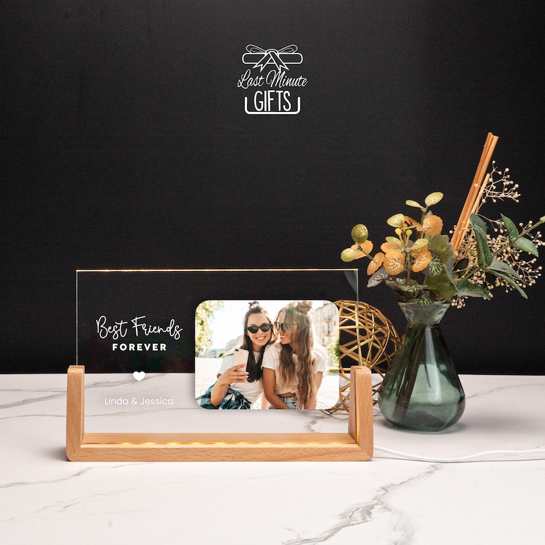 a picture frame sitting on top of a table next to a vase of flowers