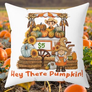 May include: White square pillow with a colorful fall-themed design. The image features a pumpkin stand with pumpkins, sunflowers, and a gnome. Text on the pillow reads "Hey There Pumpkin!"