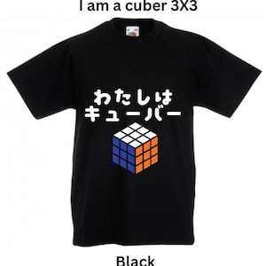 Pode incluir: Camiseta preta com o texto "I am a cuber 3x3" e o texto japonês "watashi wa kyūbu" com um gráfico de um cubo de Rubik.