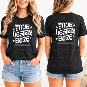 Peut inclure: T-shirt noir avec l'inscription blanche "YOUR DESIGN HERE" dans une police rétro avec des étoiles. Le t-shirt est associé à un short en jean bleu clair. L'avant et l'arrière du t-shirt sont visibles.