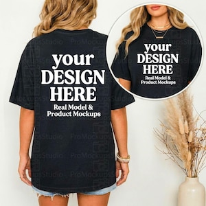 May include: Black t-shirt with the text "your DESIGN HERE" in white, ideal for mockups. The shirt is worn by a person, with a close-up in a circular frame. The text "Real Model & Product Mockups" is below the main text.