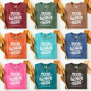 Könnte beinhalten: Ein Set aus drei Keramikbechern mit einer gesprenkelten, cremefarbenen Glasur. Jeder Becher hat ein anderes handgemaltes Design: ein blaues und grünes Blatt, eine gelbe Blume und eine rote Beere. Die Becher haben eine einfache, abgerundete Form.