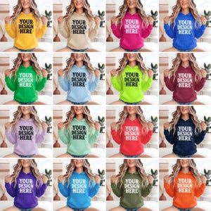 K&ouml;nnte beinhalten: Ein Raster von sechzehn Kapuzenpullovern in verschiedenen Farben, darunter Gelb, Beige, Pink, Blau, Gr&uuml;n, Hellblau, Limettengr&uuml;n, Burgunderrot, Lavendel, Mintgr&uuml;n, Rot, Marineblau, Lila, T&uuml;rkis, Olivgr&uuml;n und Orange. Jeder Pullover hat den Text "YOUR DESIGN HERE".