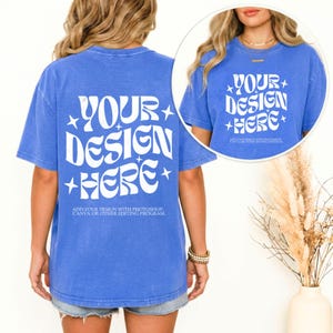May include: A blue t-shirt with the text "YOUR DESIGN HERE" in white, along with the text "ADD YOUR DESIGN WITH PHOTOSHOP, CANVA OR OTHER EDITING PROGRAM." The shirt is a short-sleeved, casual style.