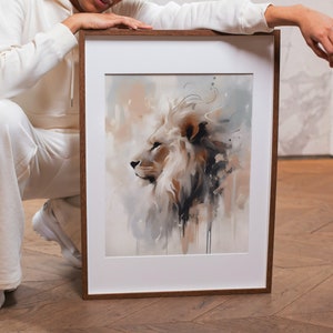 May include: A framed watercolor painting of a white lion with a brown mane. The lion is looking to the left and the background is a soft, abstract wash of colors.