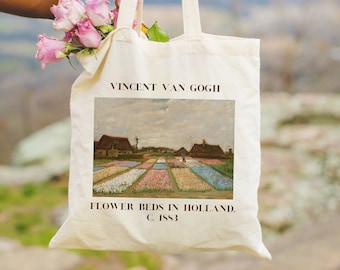 May include: A white canvas tote bag with a painting of flower beds in Holland by Vincent van Gogh. The text "FLOWER BEDS IN HOLLAND. C. 1883" is printed below the painting.