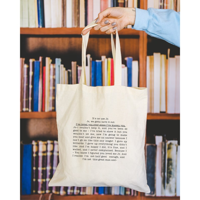 May include: A white tote bag with black text that reads "It's no use Jo. Jo, we gotta have it cut. I've loved you ever since I've known you. Je- couldn't help it, and you've been so good to me - I've tried to show it but you wouldn't let me, now I'm going to make you hear and give me an answer because I can't go on like this any longer. I gave up billiards. I gave up everything you didn't like. And I'm happy I did, it's fine, and I waited, and I never complained. Because I - You know I figured you loved me Jo. And I realize I'm not half good enough, and I'm not this great man and- "