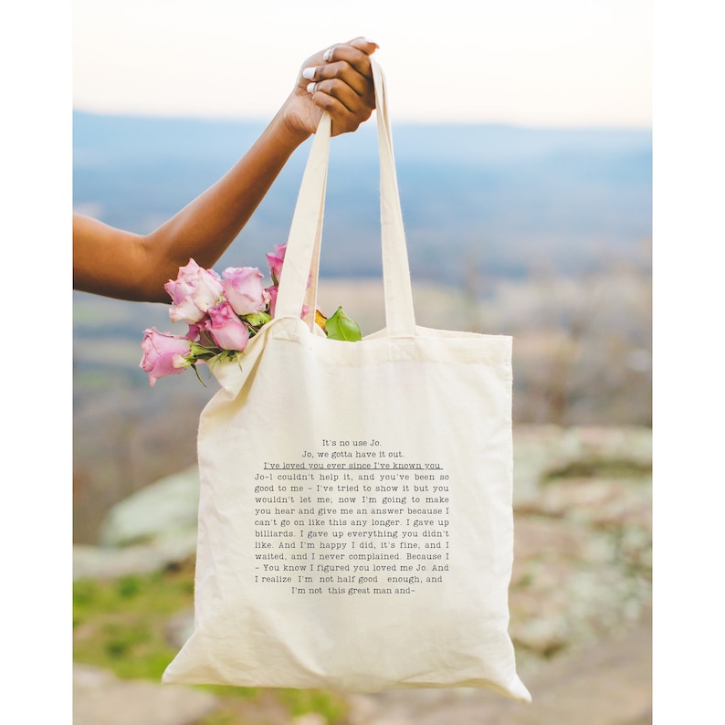 May include: A white tote bag with a black and white text message that reads: "It's no use Jo. Jo, we gotta have it out. I've loved you ever since I've known you. Jo-1 couldn't help it, and you've been so good to me - I've tried to show it but you wouldn't let me; now I'm going to make you hear and give me an answer because I can't go on like this any longer. I gave up billiards. I gave up everything you didn't like. And I'm happy I did, it's fine, and I waited, and I never complained. Because I - You know I figured you loved me Jo. And I realize I'm not half good enough, and I'm not this great man and- "