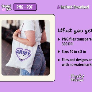 May include: A white tote bag with a purple heart design that says "ARMY" in white letters. The heart has a white circle inside with a purple star. The bag is being held by a person.