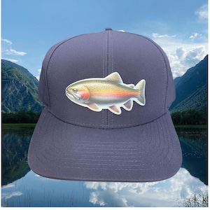 May include: A navy blue baseball cap with a rainbow trout graphic on the front. The cap has a curved brim and a mesh back.