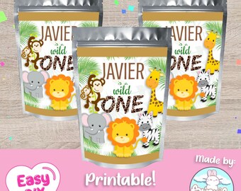 Puede incluir: Tres bolsas de aluminio plateado con etiquetas para una fiesta de primer cumpleaños. Las etiquetas presentan un tema de selva con un león, una cebra, una jirafa, un mono y un elefante. El texto en las etiquetas dice "Javier es un salvaje".