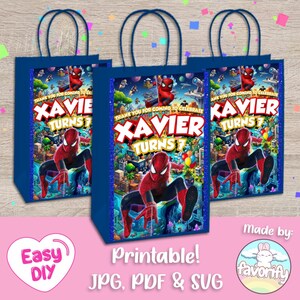 May include: Three blue paper gift bags featuring a graphic of a red and blue superhero in a city setting. The text reads: Thank you for coming to celebrate Xavier turns 7. The bags have dark blue handles and a glittery blue border on the sides.
