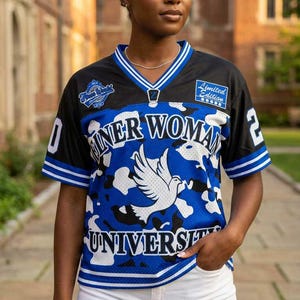 May include: Black and blue mesh jersey with white accents. The jersey features the words "Inner Woman University" and a dove graphic. The sleeves have white and blue stripes, and the number "2" is visible on the sleeve.