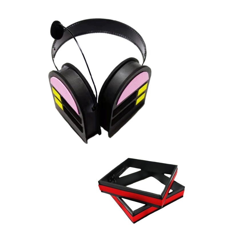 May include: Black noise-cancelling headphones with pink and yellow accents. The headphones are folded and sitting on a black and red storage box.
