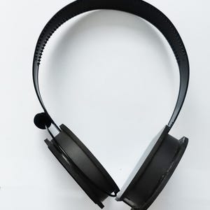 Può includere: Cuffie over-ear nere con fascia e padiglioni imbottiti.