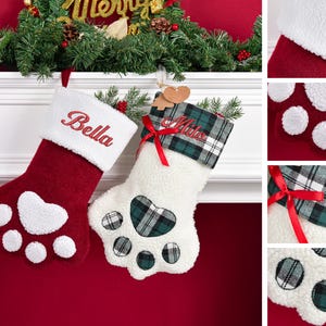 May include: Two paw-shaped Christmas stockings hanging on a white mantel. The left stocking is red with a white cuff embroidered with the name Bella. The right stocking is white with a green plaid cuff embroidered with the name Milo and a red ribbon.