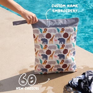 May include: A rectangular wet bag featuring a repeating pattern of colourful safari animals including giraffes, lions, elephants, hippos, and flamingos. The top grey section displays the embroidered name Yasmin and a handle for carrying.