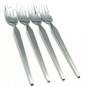 Könnte beinhalten: Set aus vier silbernen Gabeln mit modernem, minimalistischem Design. Die Gabeln haben einen schlanken, rechteckigen Griff und eine spitze Spitze.