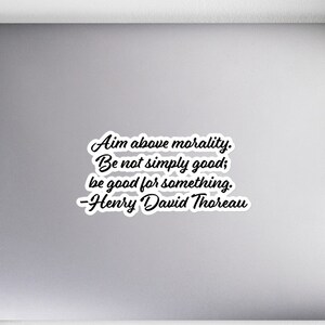 May include: A laptop computer with a sticker that reads "Aim above morality. Be not simply good; be good for something. -Henry David Thoreau"