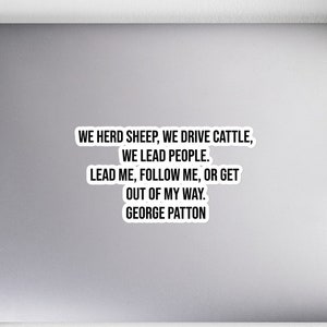 May include: A black and white sticker with a quote by General George Patton: "We herd sheep, we drive cattle, we lead people. Lead me, follow me, or get out of my way."