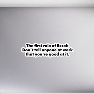 May include: A white sticker with the text "The first rule of Excel: Don't tell anyone at work that you're good at it." The sticker is on a laptop, with a notebook, pencils, headphones, and a mouse nearby.