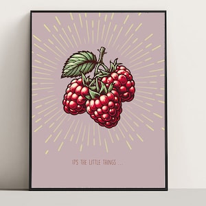 May include: A framed art print featuring a cluster of three ripe raspberries with green leaves and stems. The berries are a vibrant red, set against a light purple background with radiating yellow lines. The text "IT'S THE LITTLE THINGS..." is at the bottom.