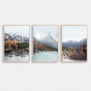 Peut inclure: Un ensemble de trois impressions encadrées représentant un paysage montagneux avec un lac turquoise au premier plan. Les montagnes sont enneigées et le ciel est bleu clair.