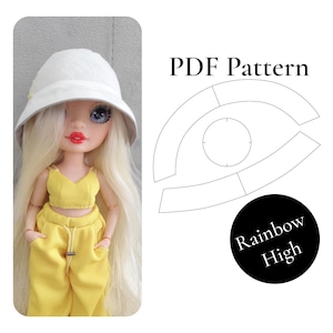 Op de afbeelding: Een pop met lang blond haar draagt een witte bucket hat, een gele crop top en een gele broek met trekkoord. Naast de pop staat een PDF-patroondiagram voor een hoed, met een cirkelvormig kroonstuk en gebogen randdelen, met de tekst Rainbow High.