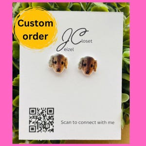 May include: A white card with the text "Custom order" in a yellow circle at the top. The card also has a QR code and the text "Scan to connect with me". Two small, round, white stud earrings with a printed image of a dog's face are displayed on the card.