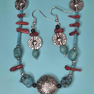 Halsband i turkos och korall med silverfärgade pärlor.