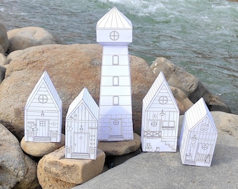 May include: Five papercraft houses, including a lighthouse, with black outlines and details on a white background. The houses are arranged on rocks near a river.