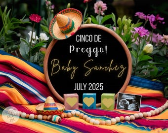 Può includere: Un cartello di ardesia nera con il testo "Cinco de Preggo! Baby Sanchez July 2025" circondato da coperte messicane colorate, un piccolo sombrero, blocchi di legno a forma di cuore e un'immagine di ecografia.