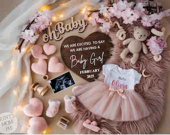 May include: A wooden heart-shaped sign with the text "We are excited to say we are having a Baby Girl February 2025".  The sign is surrounded by pink and white flowers, a pink tutu, a teddy bear, and a baby ultrasound image.