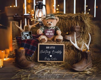 May include: A teddy bear wearing camouflage clothing sits on a bale of hay with a sign that reads "Our Little Hunting Buddy Baby Carter Coming June 2025". There are two pairs of brown boots and antlers on the hay bales.
