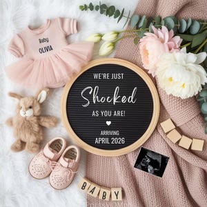 May include: A baby announcement featuring a pink tutu dress, shoes, and a stuffed bunny. A letter board reads "We're just shocked as you are!" with the arrival date of April 2026. A sonogram is also included.