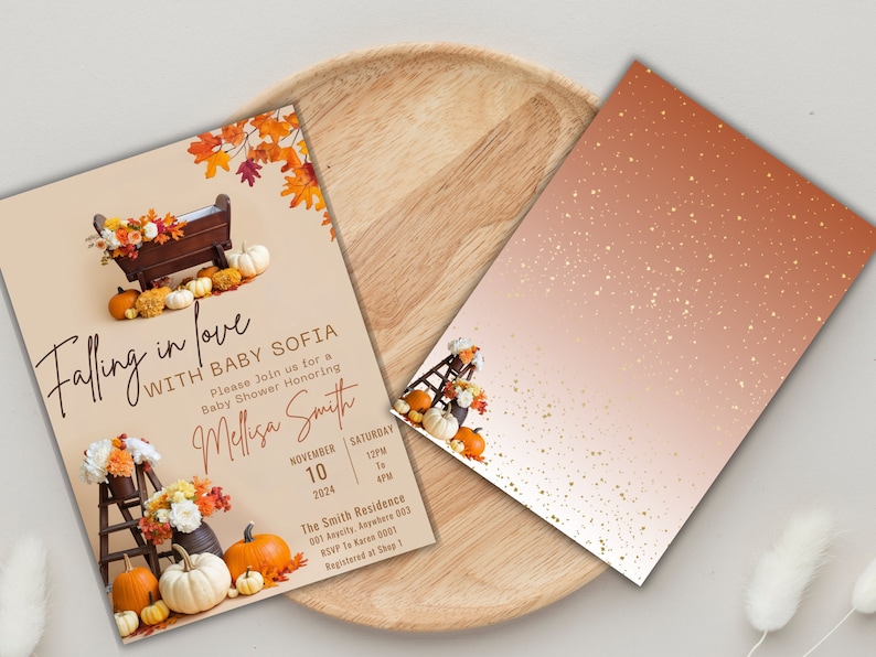May include: A baby shower invitation with a fall theme. The invitation features a wooden cradle with pumpkins and fall leaves. The text on the invitation reads "Falling in love with Baby Sofia".